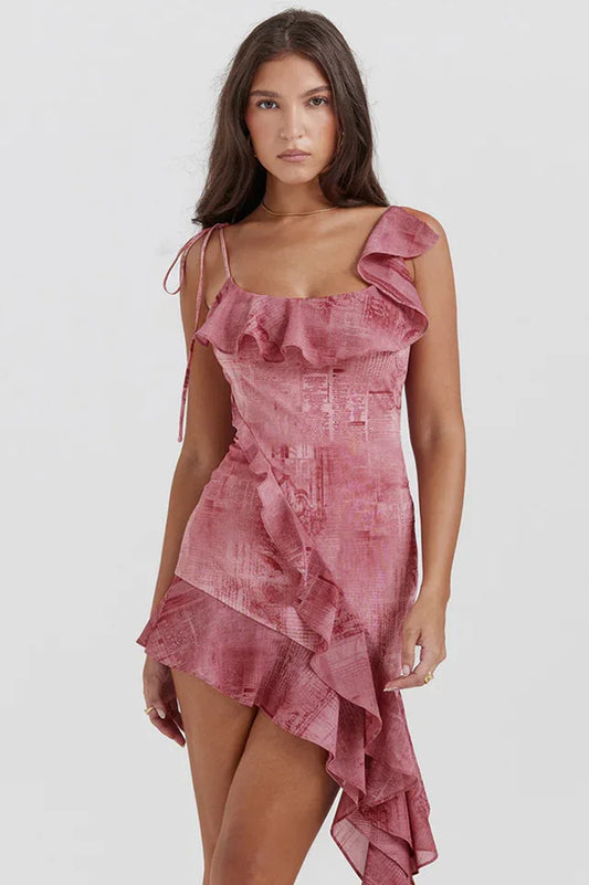 Woman wearing a pink printed mini dress with ruffled trim and asymmetrical hem