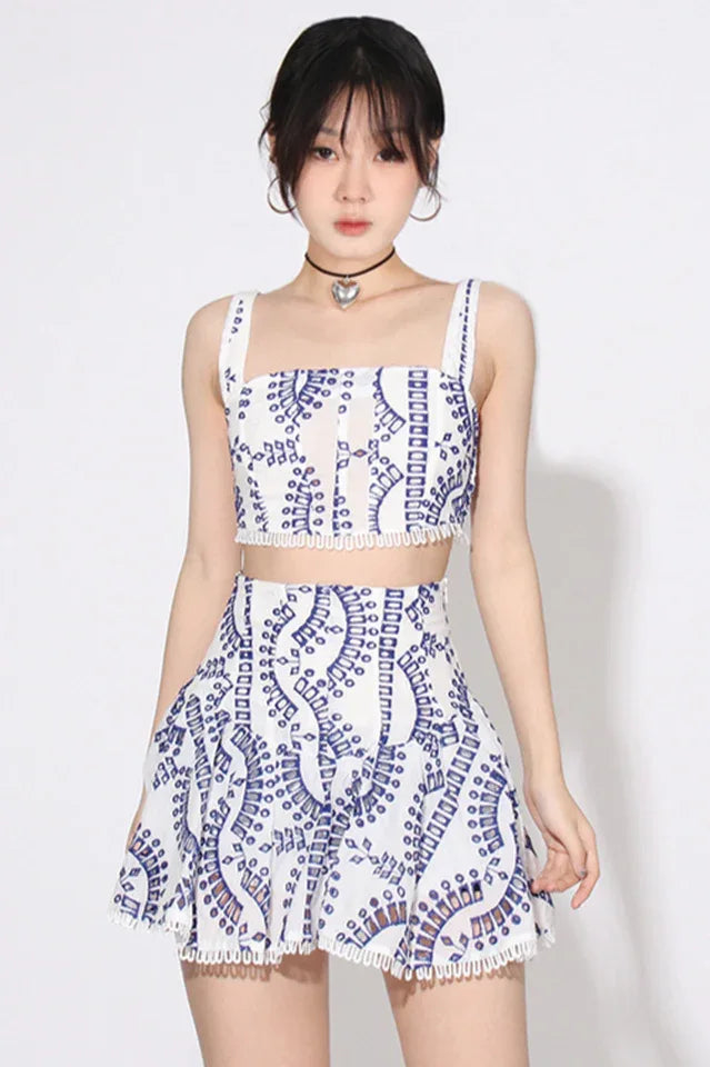 Woman wearing a white and blue embroidered eyelet crop top and flared skirt set. Main image