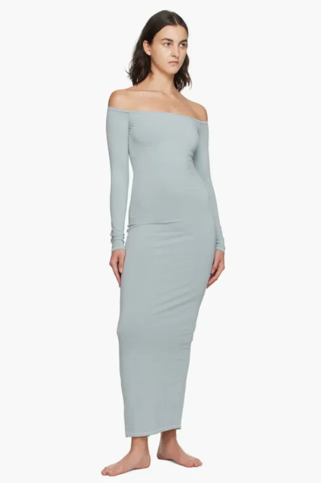 Model wearing a light blue off-the-shoulder maxi dress from the side
