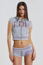 Model wearing a gray cropped zip-up hoodie with short sleeves and sequin embellishments on the front, paired with matching shorts.