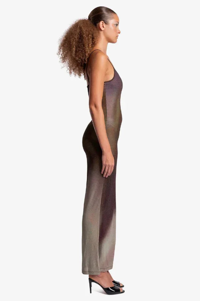 Woman wearing a sheer, ombre knit maxi dress with spaghetti straps, side view.