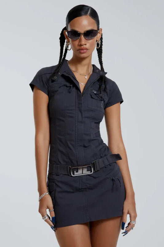 Woman wearing a dark grey short-sleeve mini dress with a collar, zipper closure, belted waist, and cargo pockets.