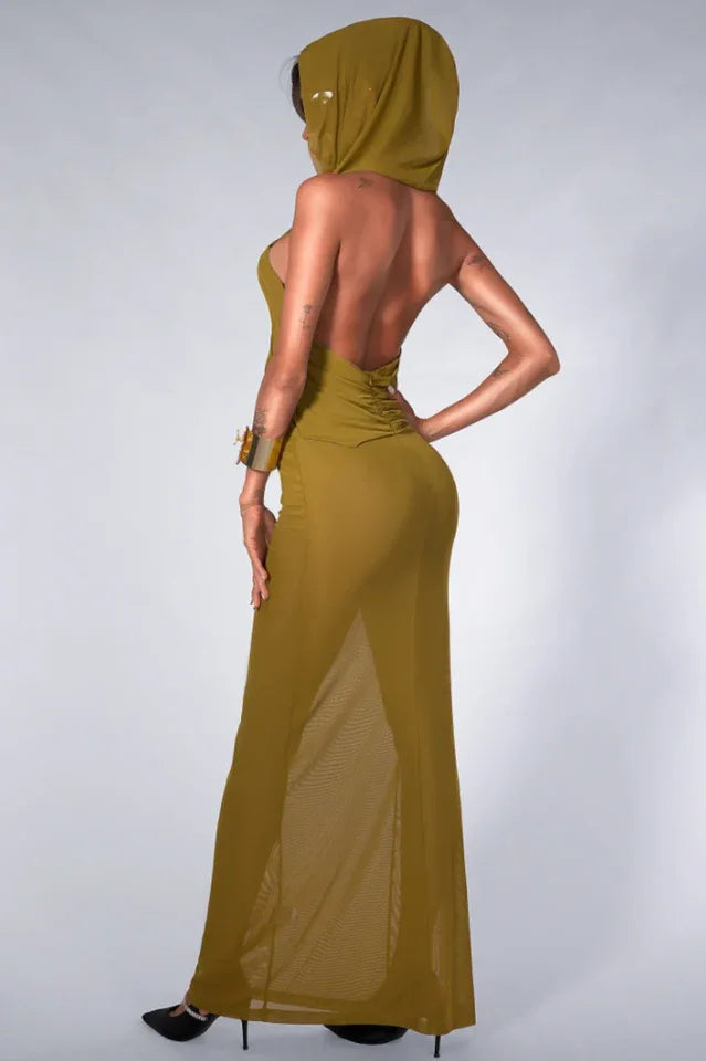 Back view of a model in an olive green hooded maxi dress, highlighting the open back and sheer skirt.