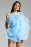 Woman wearing a light blue one-shoulder mini dress with a large floral appliqué on the bodice.