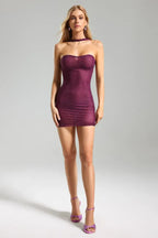 Full body shot of a woman in a purple strapless mini dress with embellishments and a halter neckline.