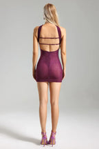 Back view of a woman in a purple strapless mini dress with an open back detail and embellishments.