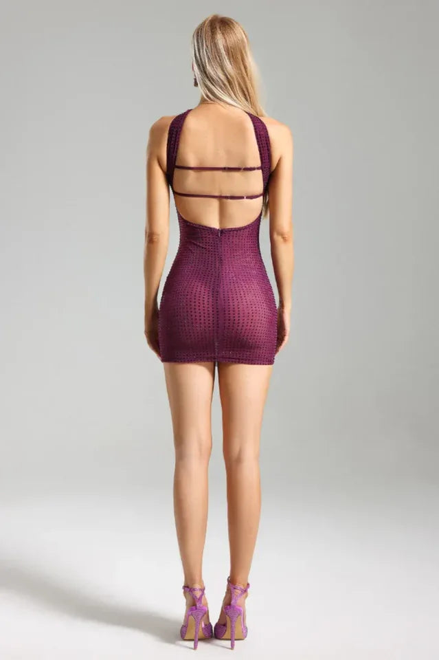 Back view of a woman in a purple strapless mini dress with an open back detail and embellishments.