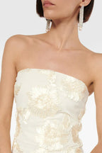 Close-up of the strapless neckline of an ivory gown adorned with detailed floral embroidery, showing the texture and craftsmanship.