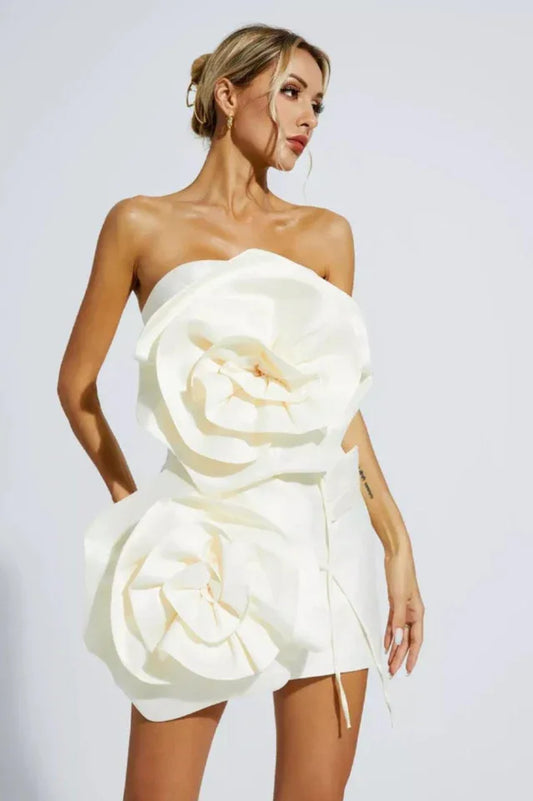 Close-up of the white strapless mini dress featuring prominent floral embellishments.