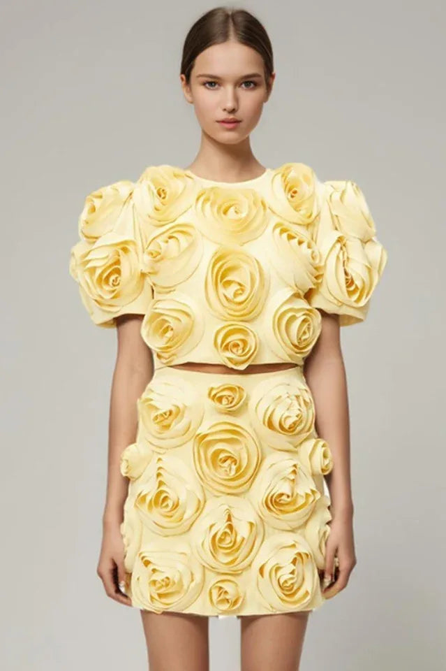 Model wearing a yellow cropped top with 3D floral embellishments and matching mini skirt Main image