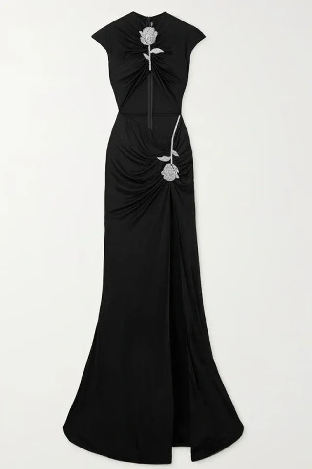 Full view of a black velvet evening gown with a cut-out, high slit, and rose embellishment.