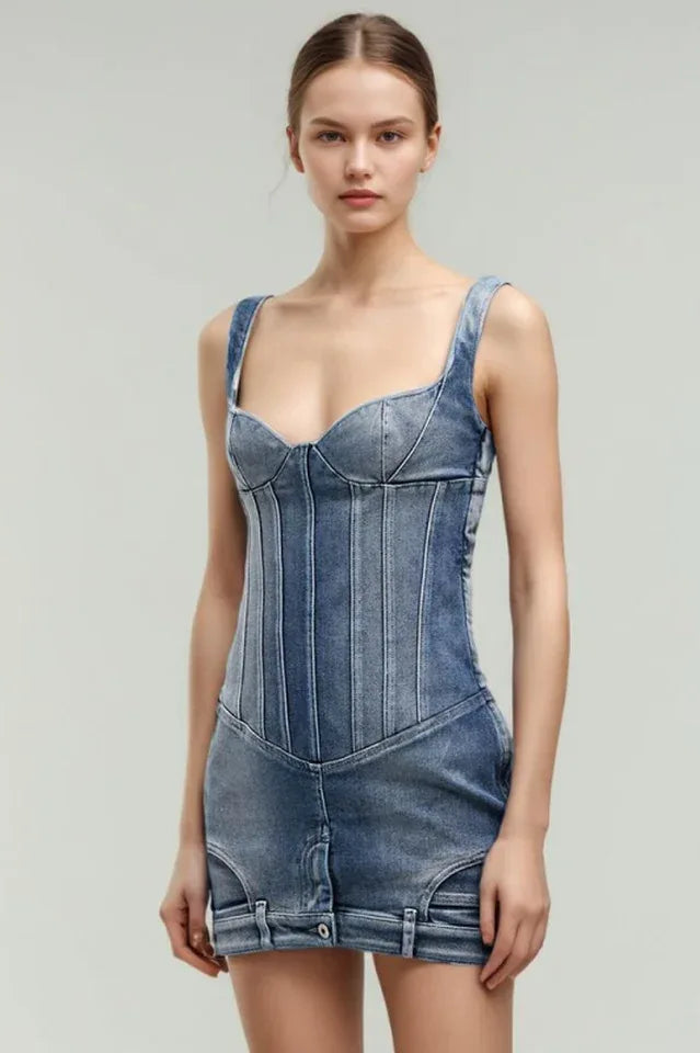 Model wearing a blue denim corset mini dress with strap shoulders, viewed from the front.
