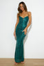 Full-length view of a woman in an emerald green sequined evening dress.