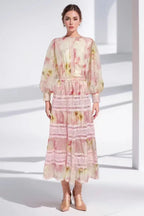 Woman wearing a pink floral print maxi dress with puff sleeves and lace trim