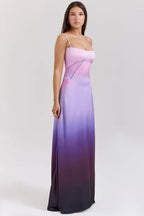 Woman wearing a pink and purple ombre satin maxi dress with spaghetti straps and a square neckline, shown from the side.