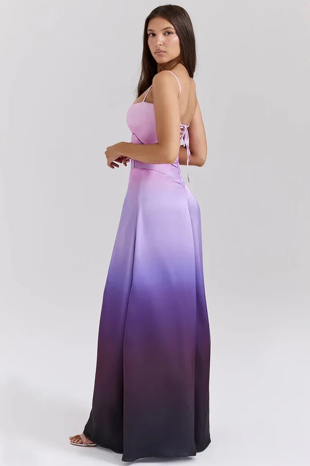 Woman wearing a pink and purple ombre satin maxi dress with spaghetti straps and a square neckline, shown from the back, highlighting the lace-up detail.