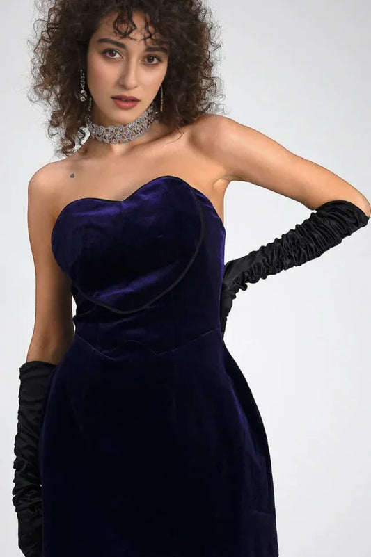 Close-up of the model's upper body, showcasing the velvet dress, gloves, and jewelry.