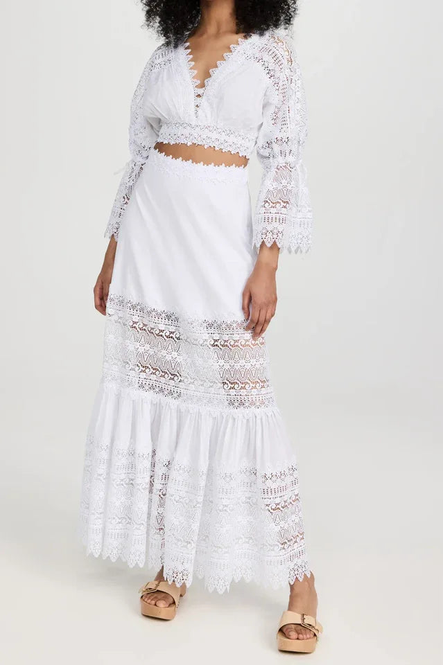 Woman wearing a white lace cropped blouse and matching white lace maxi skirt, standing against a white background. Main image