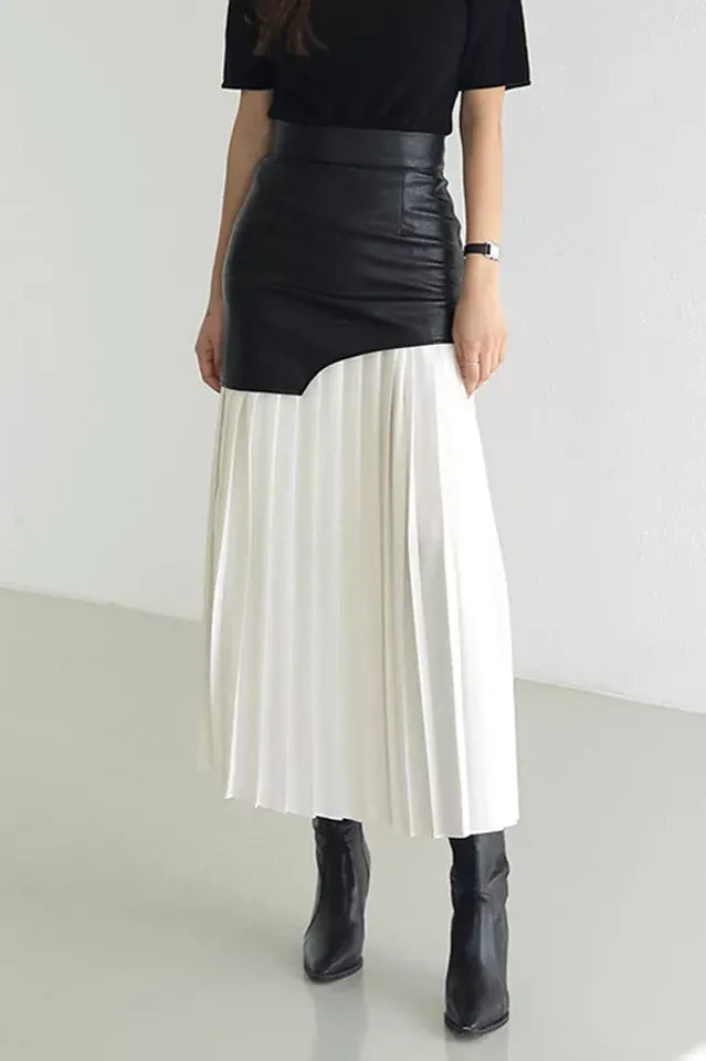 Model wearing a black and white paneled pleated skirt with black boots Main image