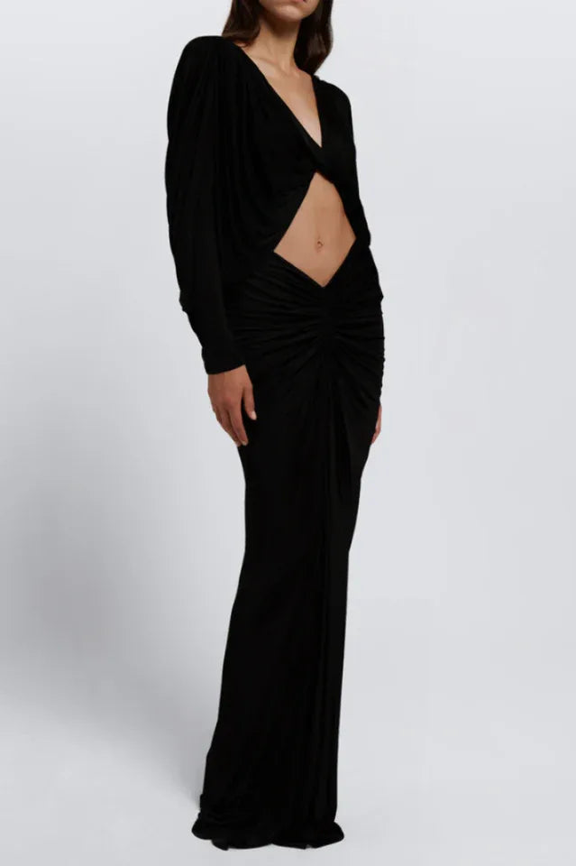 Woman wearing a long black dress with a cut-out detail and long sleeves Main image