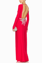 Red long sleeve sheath gown with a deep open back embellished with silver detailing