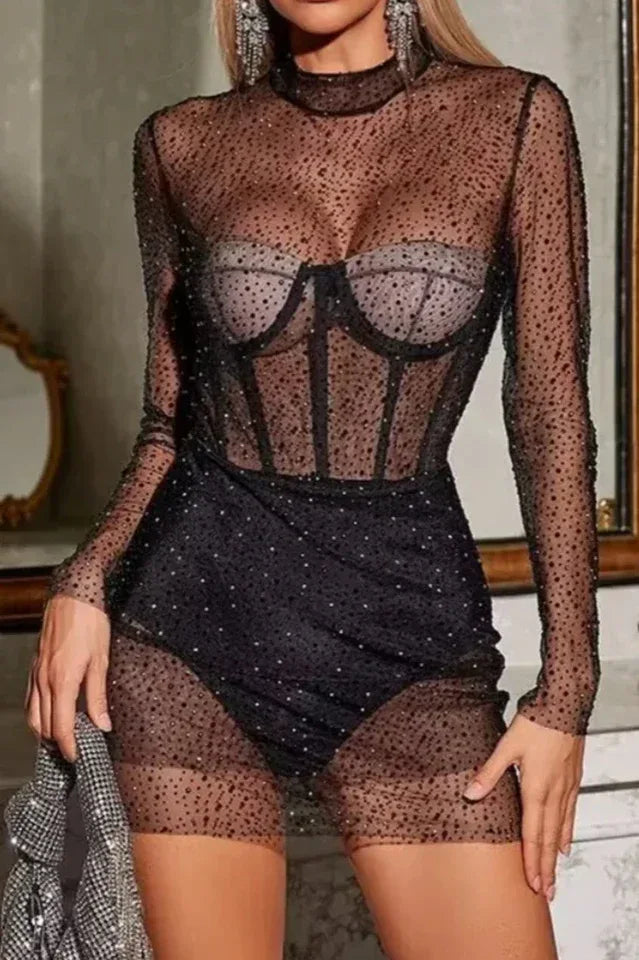Close-up of a black sheer long-sleeve dress with sparkle embellishments. Secondary image
