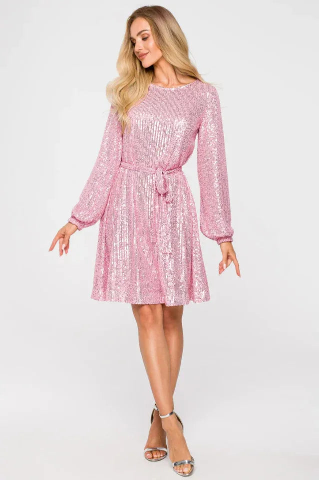 Woman wearing a pink sequined A-line dress with long sleeves and a round neckline, cinched at the waist with a matching belt, paired with silver strappy heels. Main image
