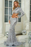Woman wearing a silver sequin two-piece evening gown with a crop jacket and mermaid skirt, posing in front of a white door with columns.