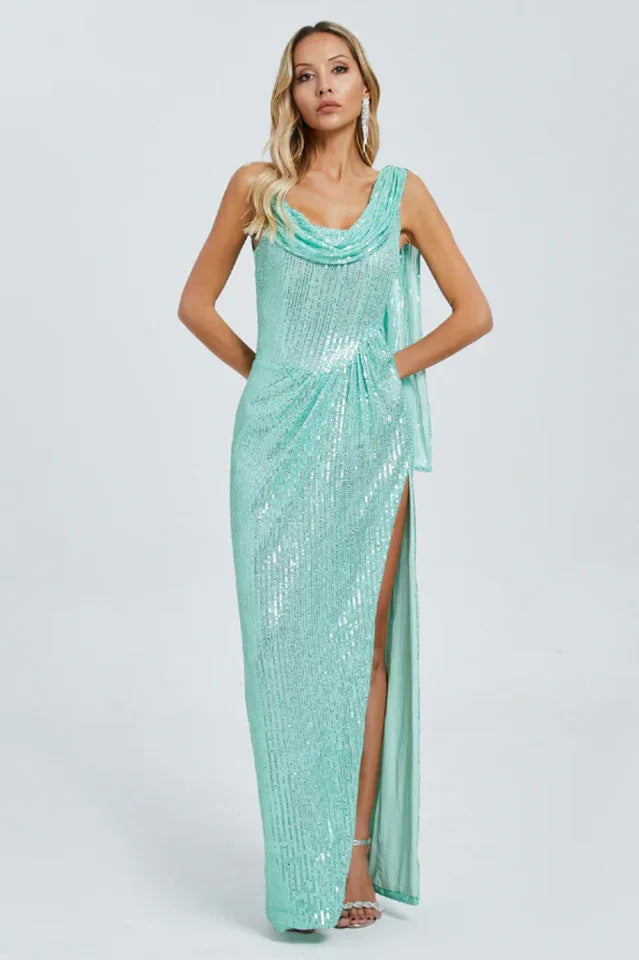 Woman wearing a shimmering mint green sequined column gown with a high slit and cowl neckline.