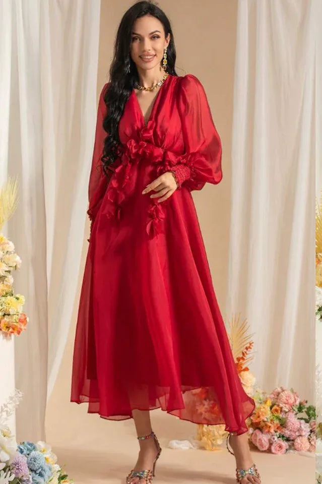 Woman wearing a long red chiffon dress with floral appliqués and bishop sleeves Main image