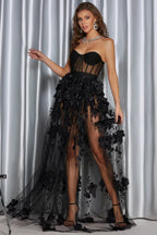 Rear view of a woman in an elegant black formal dress with a sheer, flowing skirt