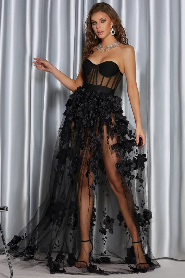 Rear view of a woman in an elegant black formal dress with a sheer, flowing skirt