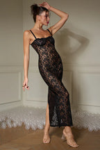 Side profile of a woman posing in a black lace maxi dress.