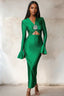 Woman wearing a long green satin dress with long flared sleeves and a cutout waist