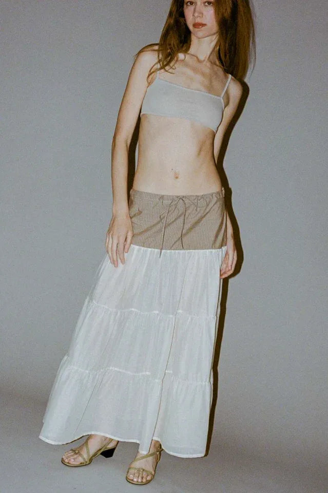 Model wearing a light gray crop top and a tiered maxi skirt with a brown pinstripe waistband, standing against a gray backdrop. Main image