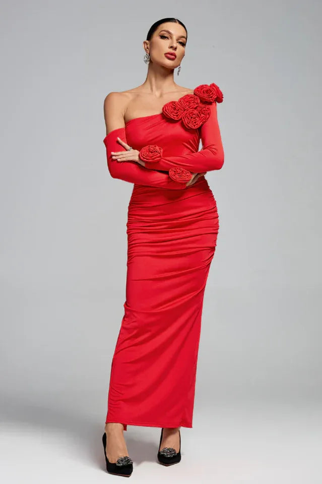 Woman in a red one-shoulder gown with rose embellishments and a ruched skirt.