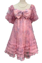 Pink floral print tulle dress with puff sleeves and a large bow detail on the bust, displayed on a mannequin.