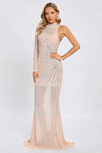 full-length view of a woman wearing a pale pink, heavily embellished gown with an asymmetrical neckline
