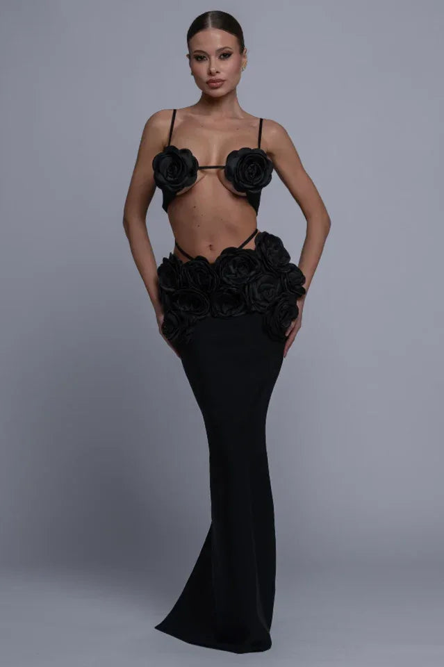 Woman wearing a black two-piece evening gown with rose embellishments on the bust and waist Main image