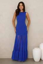 woman wearing a royal blue sleeveless maxi dress with a sheer tiered ruffle hem, front view