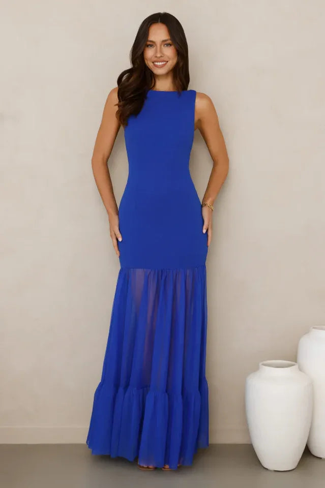 woman wearing a royal blue sleeveless maxi dress with a sheer tiered ruffle hem, front view