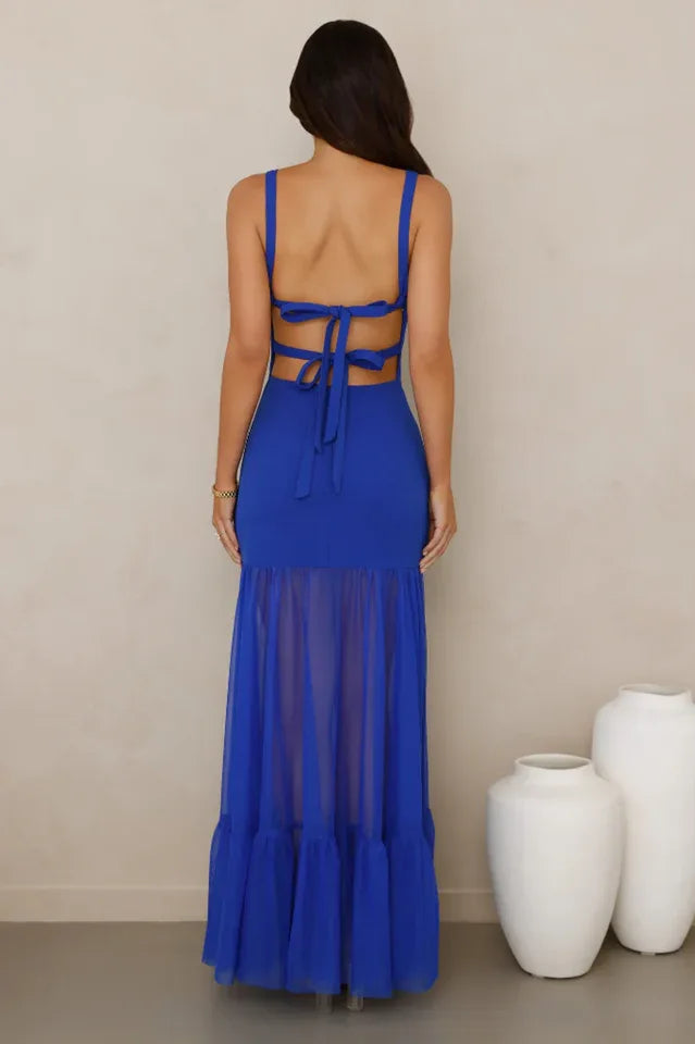 back view of a woman wearing a royal blue sleeveless maxi dress with an open back and tie detail