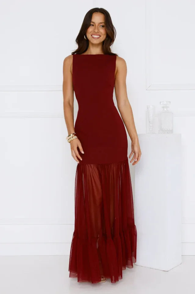 woman wearing a burgundy sleeveless maxi dress with a sheer tiered ruffle hem