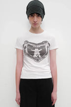Model wearing a white crew neck t-shirt with a black and white graphic print on the chest and a black and grey striped beanie.