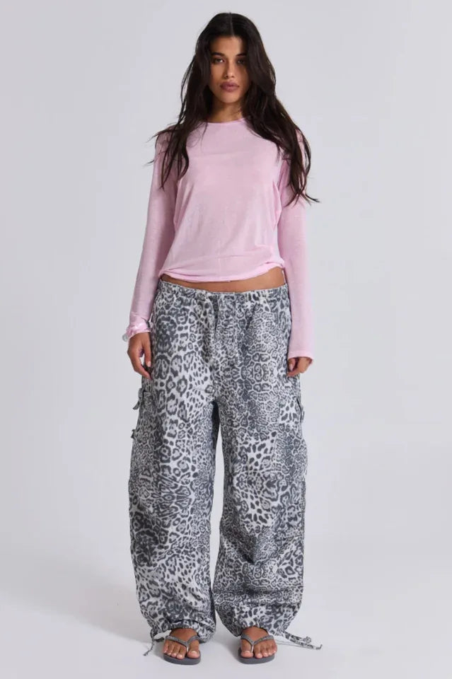 Model wearing a pink long-sleeve top and leopard print cargo pants. Secondary image