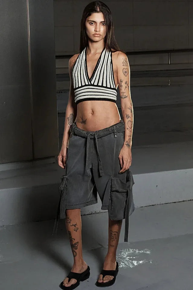 Model wearing a cropped halter top and charcoal cargo shorts.