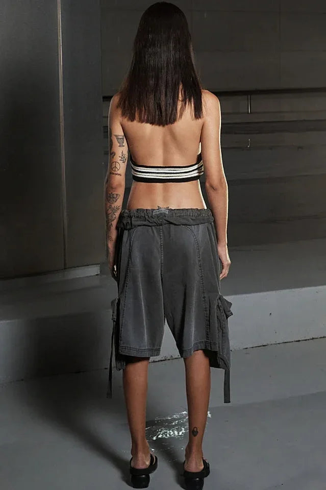 Back view of a model wearing a halter top and cargo shorts.