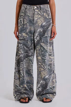 Close-up of the front of camouflage wide-leg jeans worn by a woman.