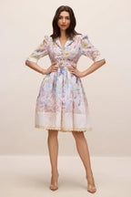 Full body shot of a woman posing in a floral print midi dress with her hands on her hips