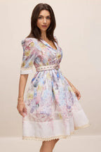 Side profile of a woman in a floral print A-line dress with puff sleeves and lace trim
